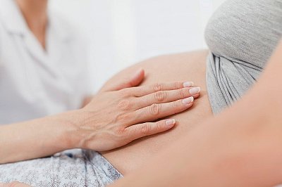 Doctor examining pregnant womans belly